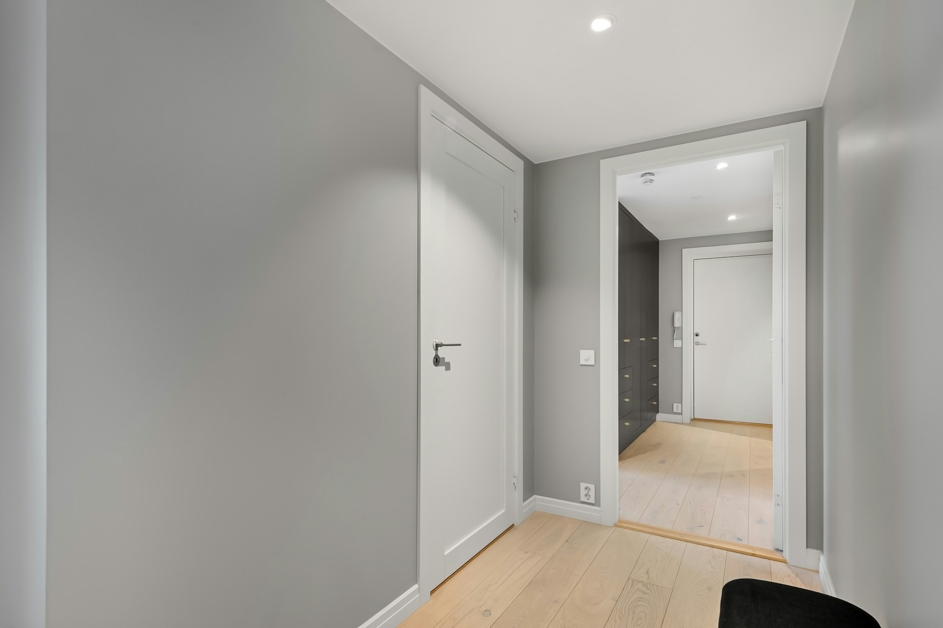 Hallway with clean white trim, wainscoting and door casings